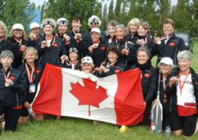 River Spirit paddlers holding a Canadian flag at a dragon boat festival