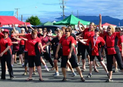 River Spirit paddlers doing a group warm-up on shore at a regatta