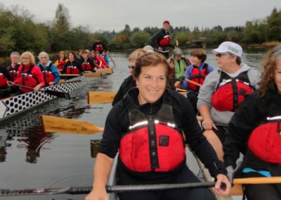 River Spirit paddlers in life jackets seated in the dragon boat