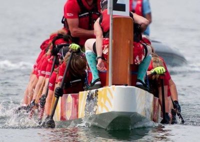 River Spirit paddlers racing in their dragon boat with the drummer at the front