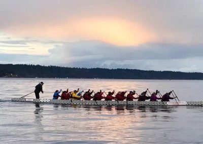 River Spirit dragon boat crew paddling at sunset near Campbell River